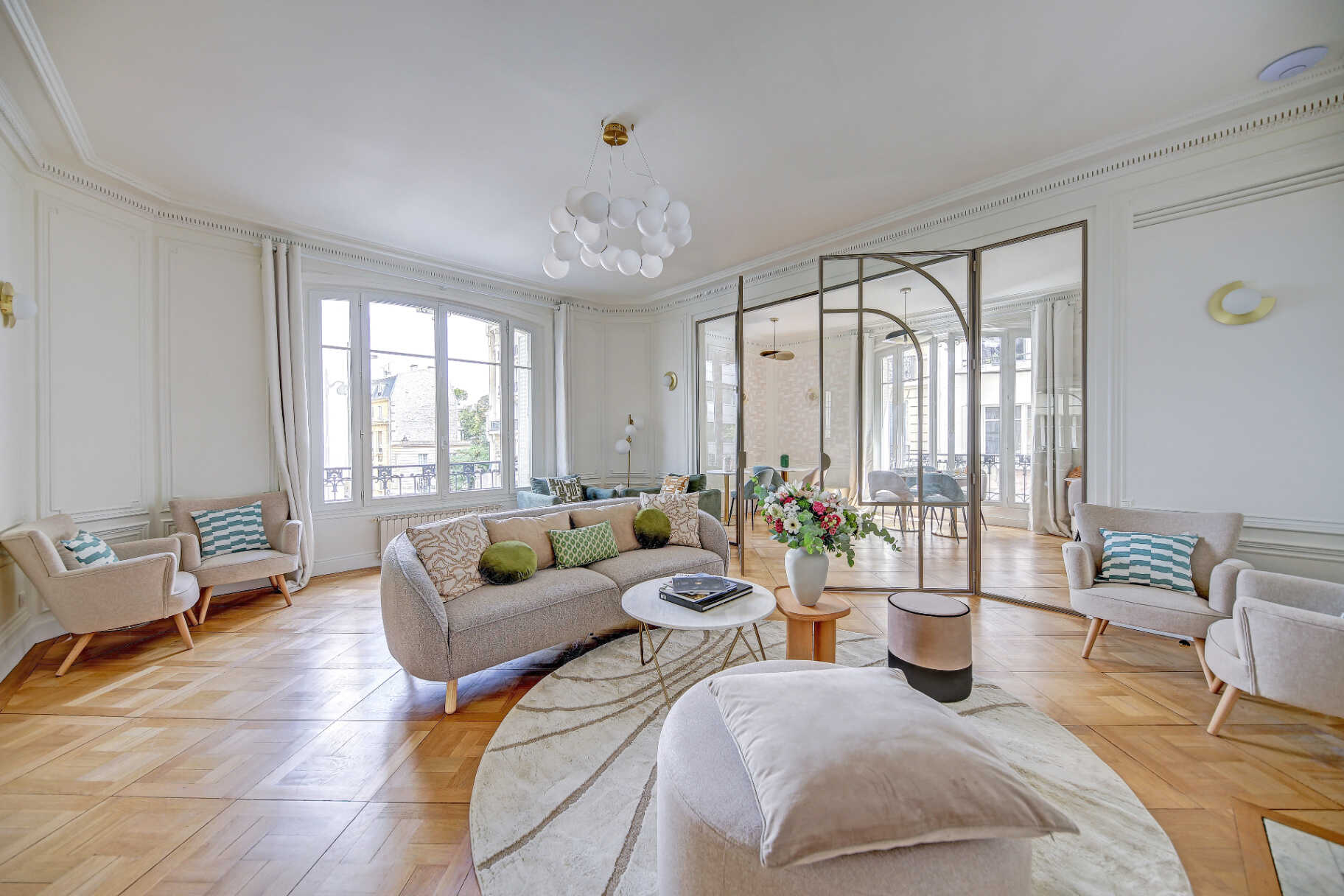 Main lounge with Haussmann-style high ceilings and herringbone parquet