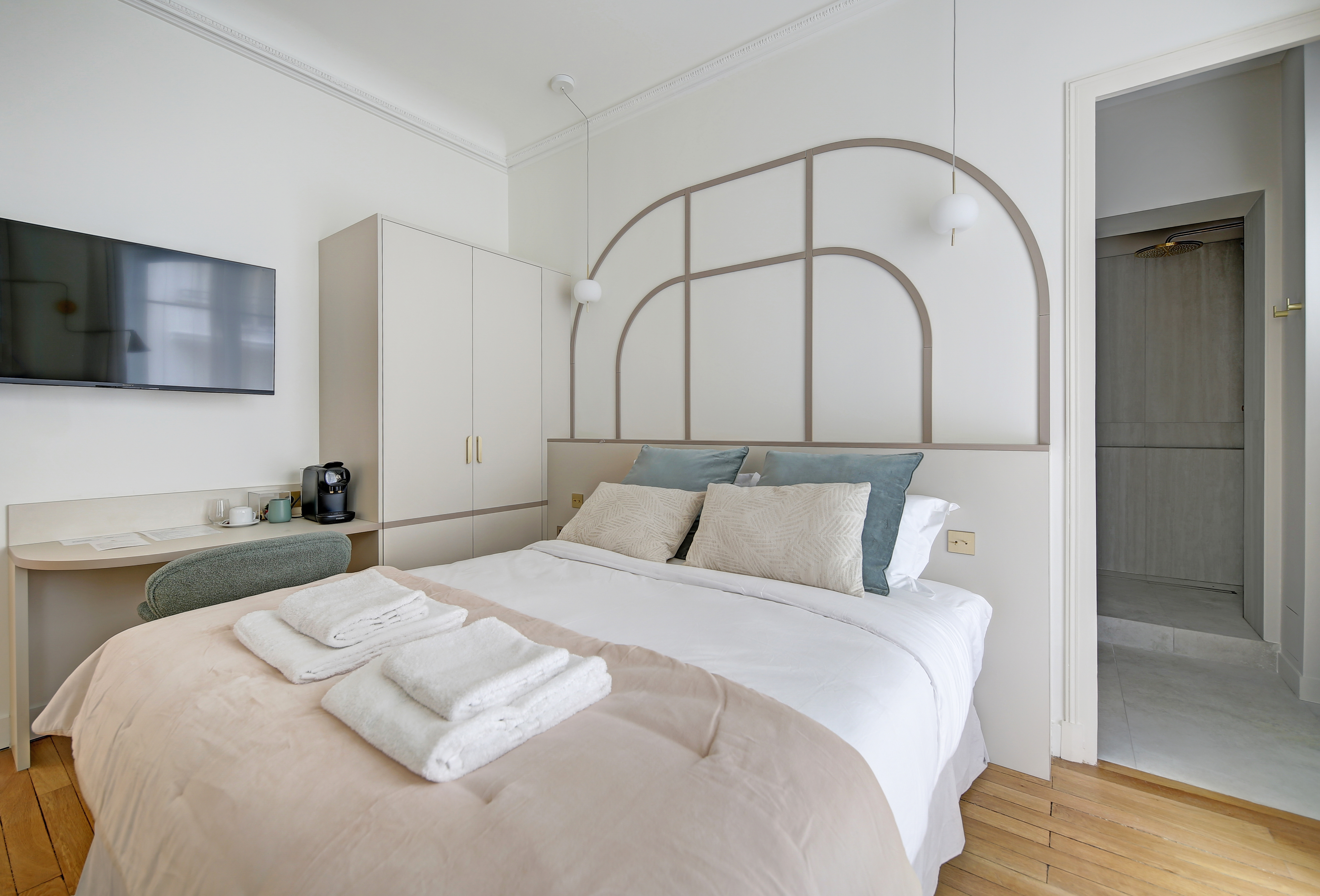 Spacious bedroom with large windows overlooking Parisian streets